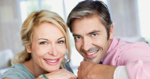 middle aged couple showing off their beautiful smiles