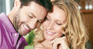 Couple looks down and smiles after getting inlays and onlays