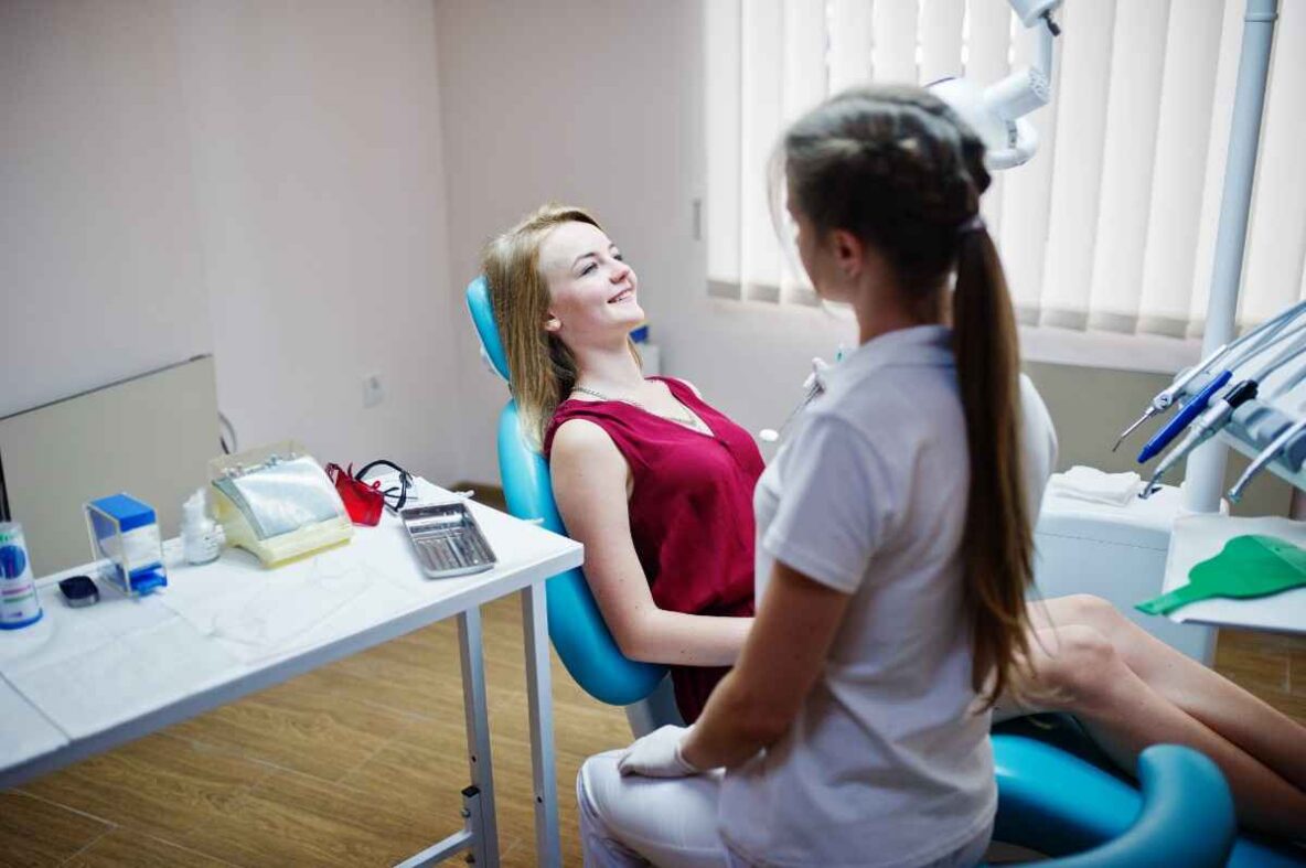 Young patient relaxing in a dental chair while speaking with a dentist during a pediatric dental visit.