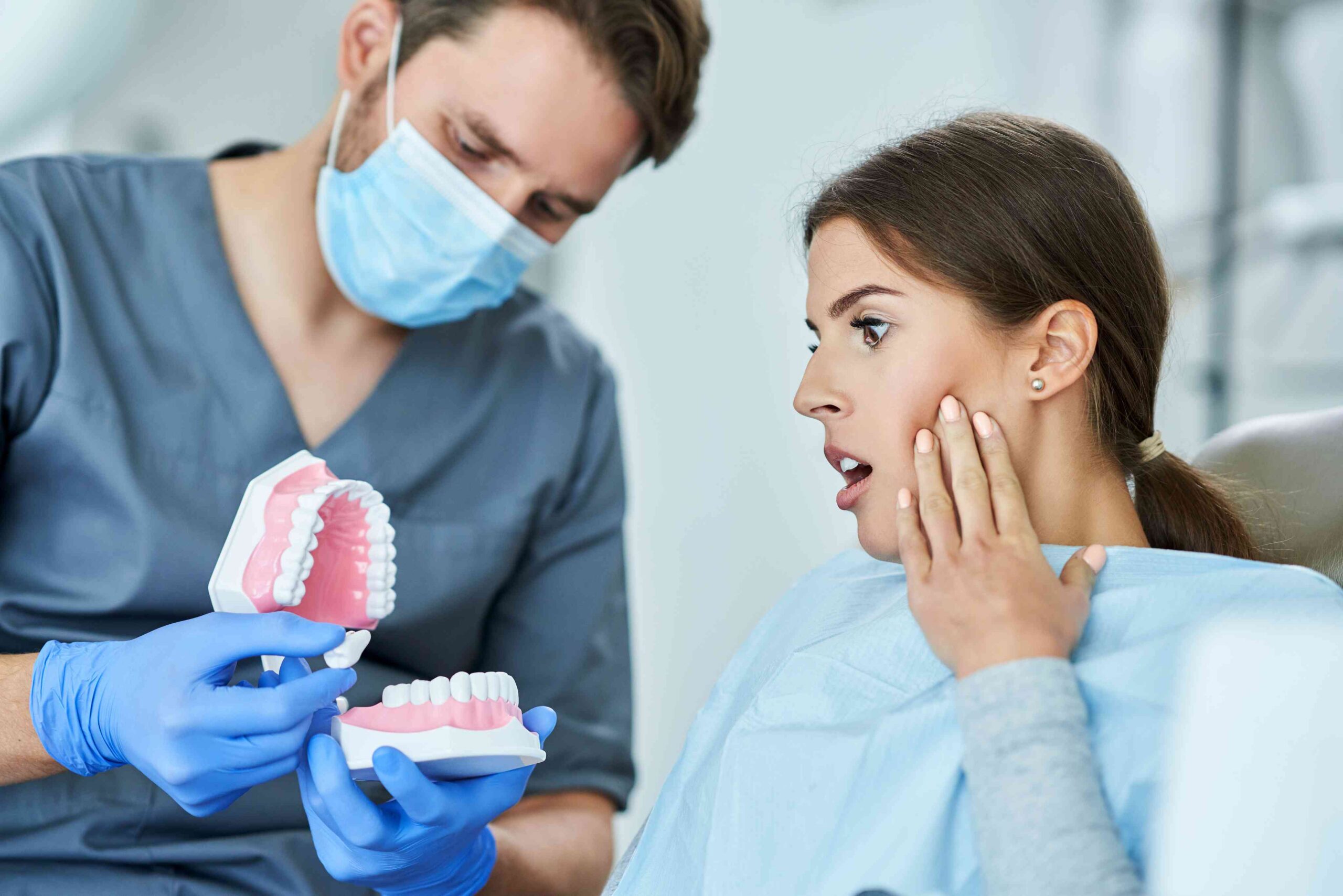 Concerned patient discussing tooth pain with a dentist.