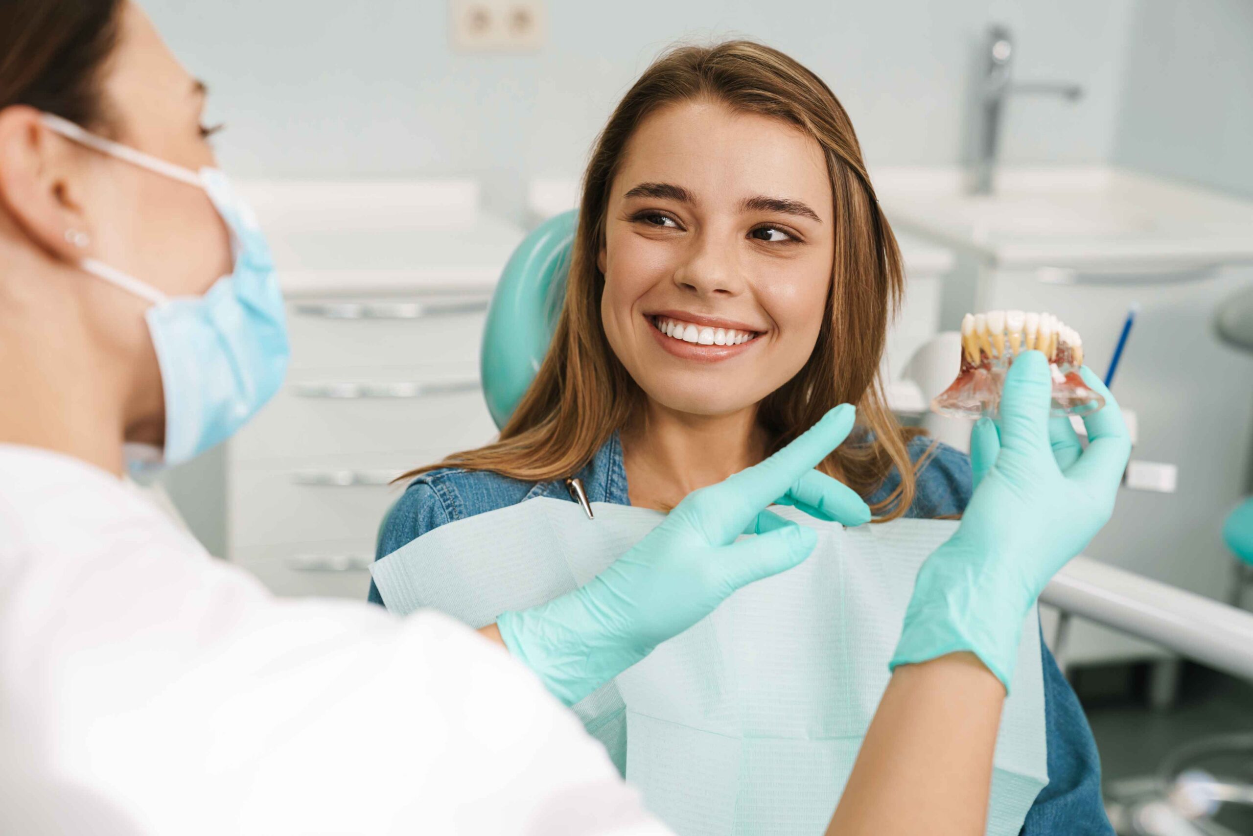 Dentist explaining Invisalign treatment using a teeth model.